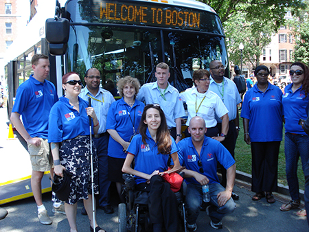 Secretary of Transportation Stephanie Pollack and MBTA staff at the ADA Celebration on Boston Common. The 1400 series MBTA bus in the background is an accessible, low-floor vehicle with a wheel chair ramp. Folding seats in the fore section of the vehicle provide wheelchair access (photo above). Back row (left to right): Ithai Larsen, Ali Abdelouahhab, Secretary Pollack, Patrick Welter, Lorraine Lansburg, Marquise Boggs, Martha Glover, and Dee Burgos. Front row (left to right): Miriam Cooper, Laura Brelsford, Kurt Echols.