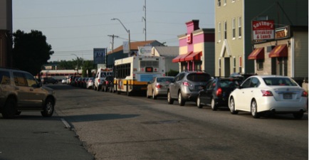 FIGURE 9. Everett Avenue Railroad Grade Crossing during the Morning Peak Period
Figure 9 shows 17 autos, an MBTA bus, and a lift van waiting behind a railroad crossing gate for a commuter rail train to pass.