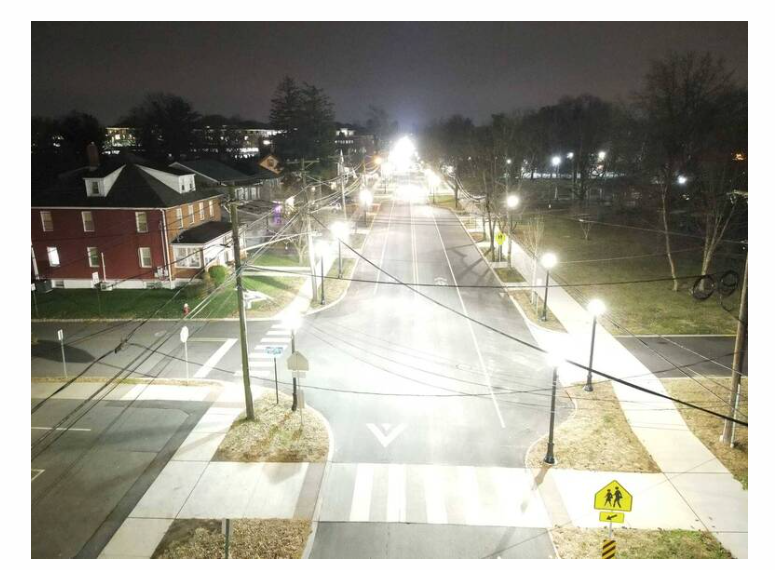 A street illuminated by harsh white light. 